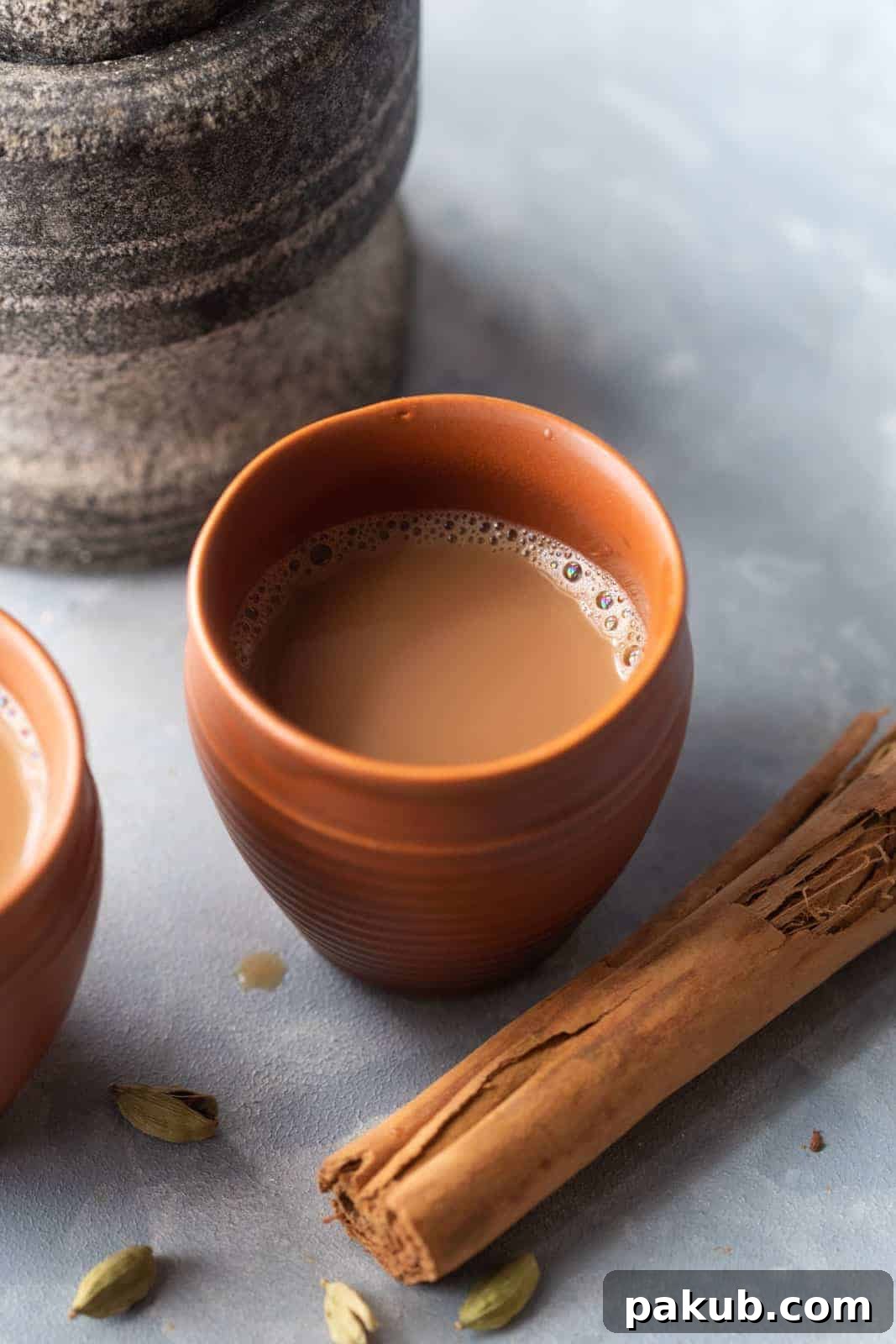 Chai Secrets Revealed 5 Recipes to Master 4 A rich, creamy Masala Chai served in a traditional terracotta mug, exuding warmth and spice.