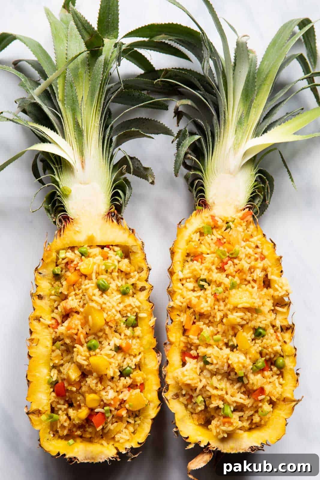 Vegan Thai Pineapple Fried Rice 2 Thai Pineapple fried rice served in elegant pineapple boats, garnished with fresh herbs