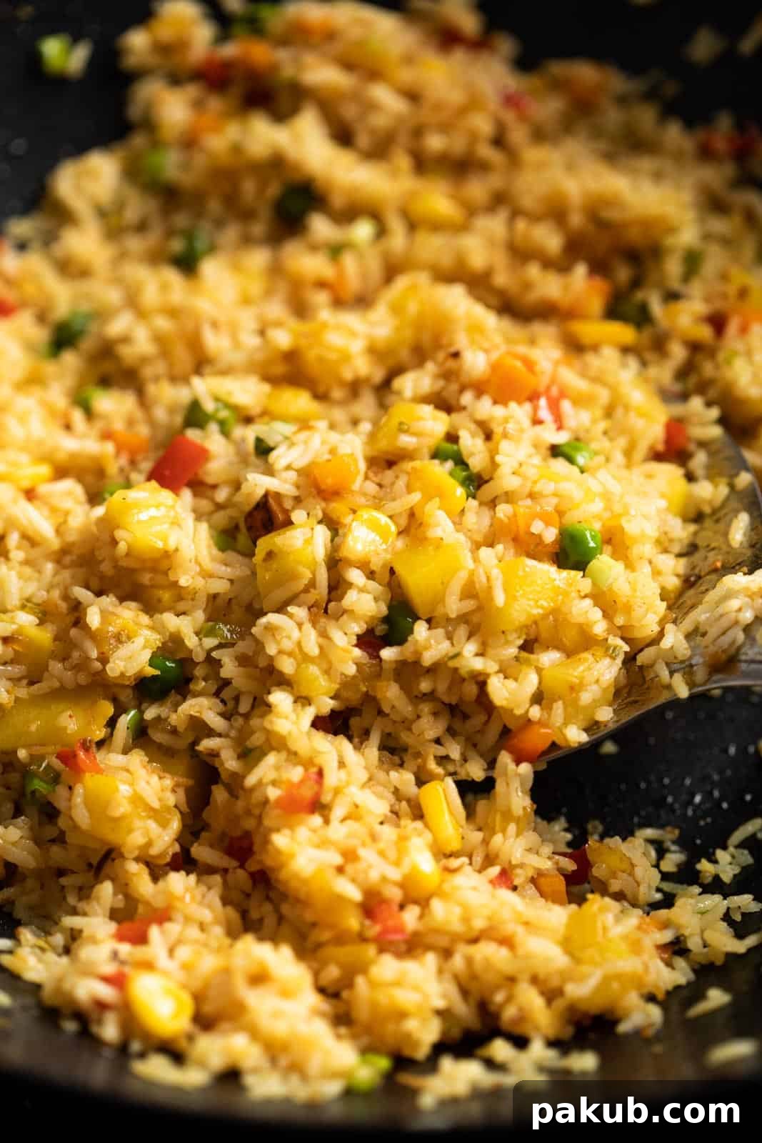 Vegan Thai Pineapple Fried Rice 3 Closeup of vibrant Thai Pineapple Fried Rice simmering in a hot wok, showing colorful ingredients