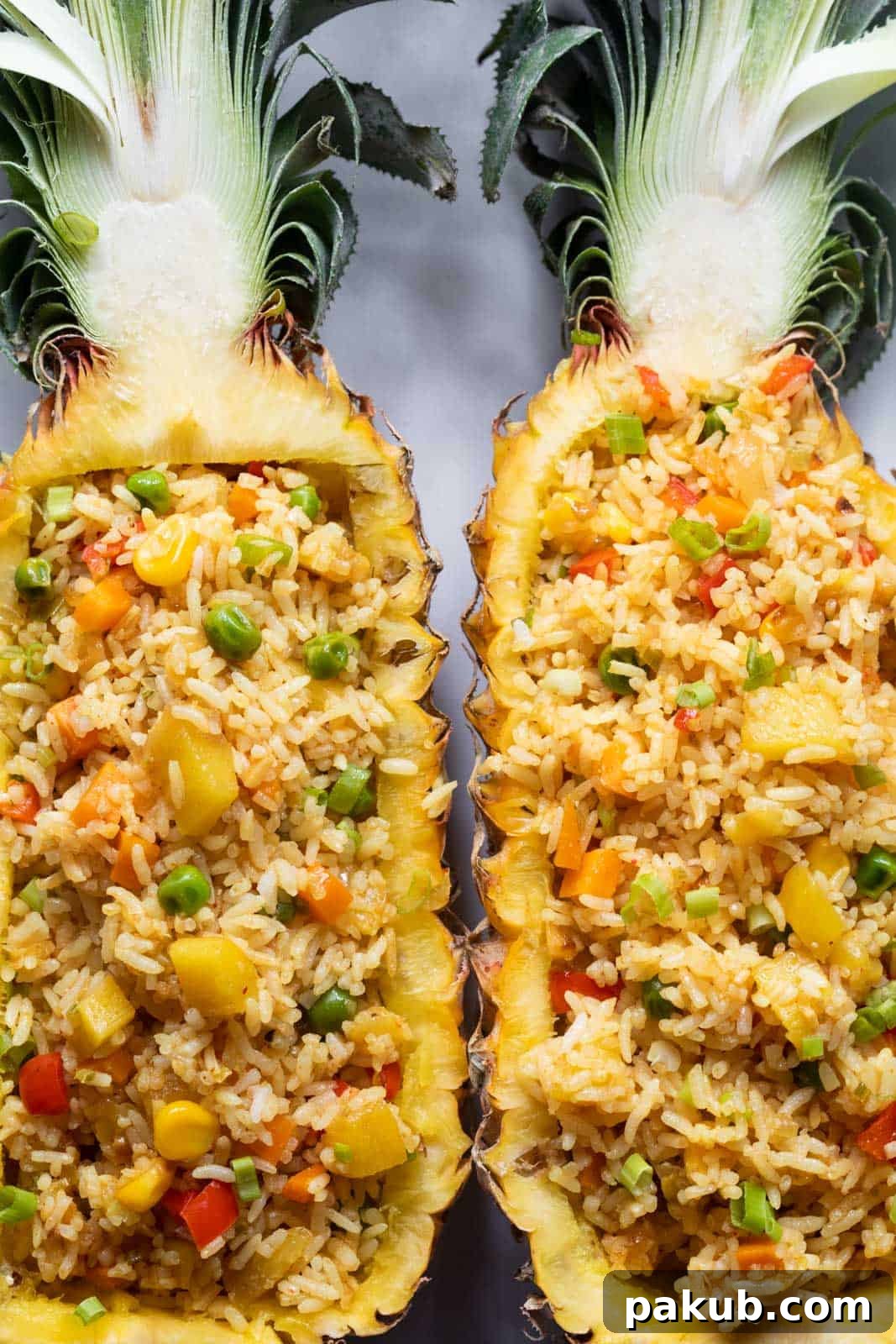 Vegan Thai Pineapple Fried Rice 4 Thai Pineapple fried rice elegantly presented in half pineapple shells, garnished with fresh cilantro