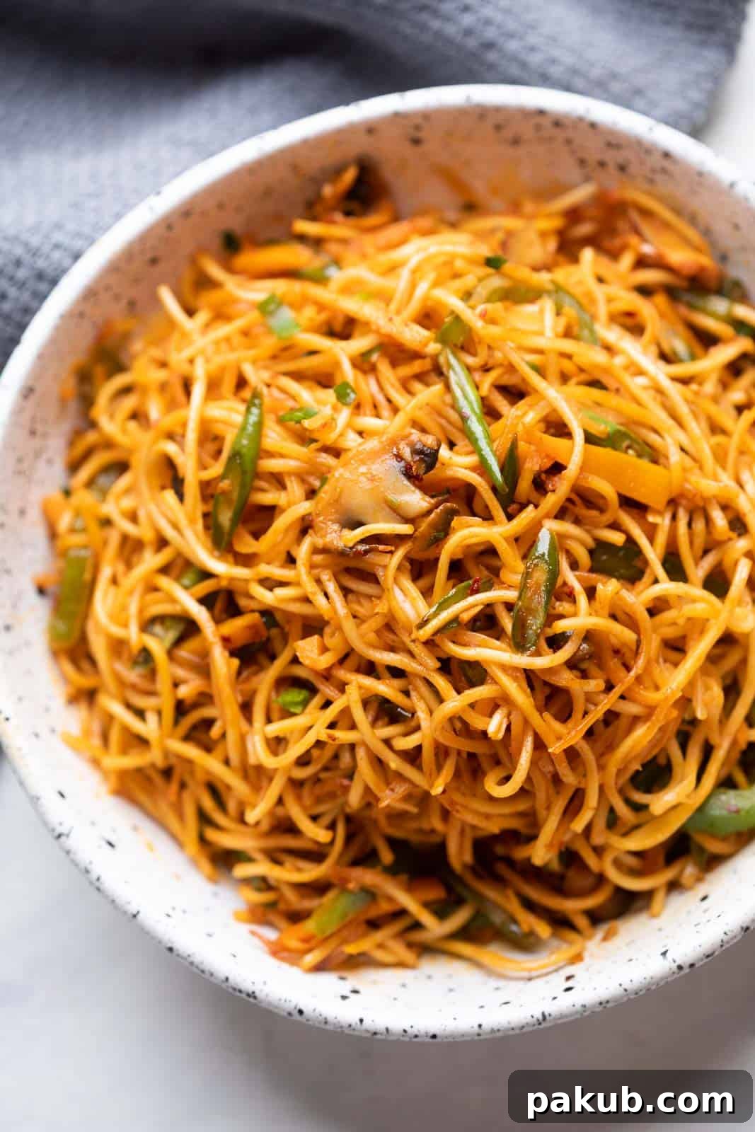 Chilli Garlic noodles served in a white textured bowl, ready to be enjoyed.