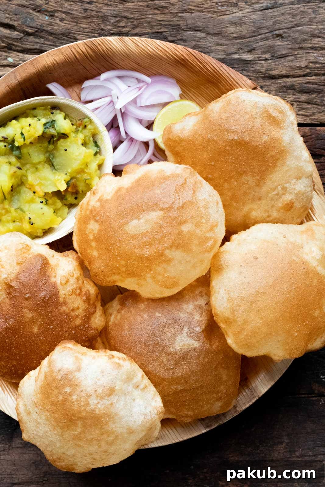 Perfect Pooris: Feather-Light and Fluffy 3 Pooris served on a plate with aloo bhaji, onions