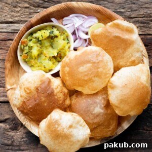 Perfect Pooris: Feather-Light and Fluffy 4 Pooris served on a plate with aloo bhaji, onions