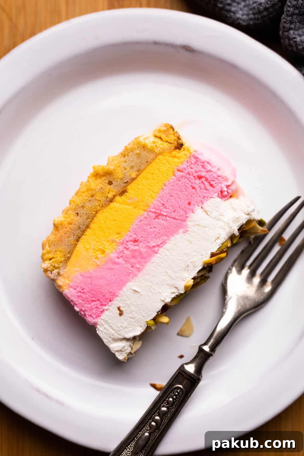 Modern Cassata Cheesecake 3 A close-up of a delectable slice of Cassata 2.0 with its signature cheesecake layer, perfectly presented on a plate with a fork, highlighting its inviting texture and distinct layers.
