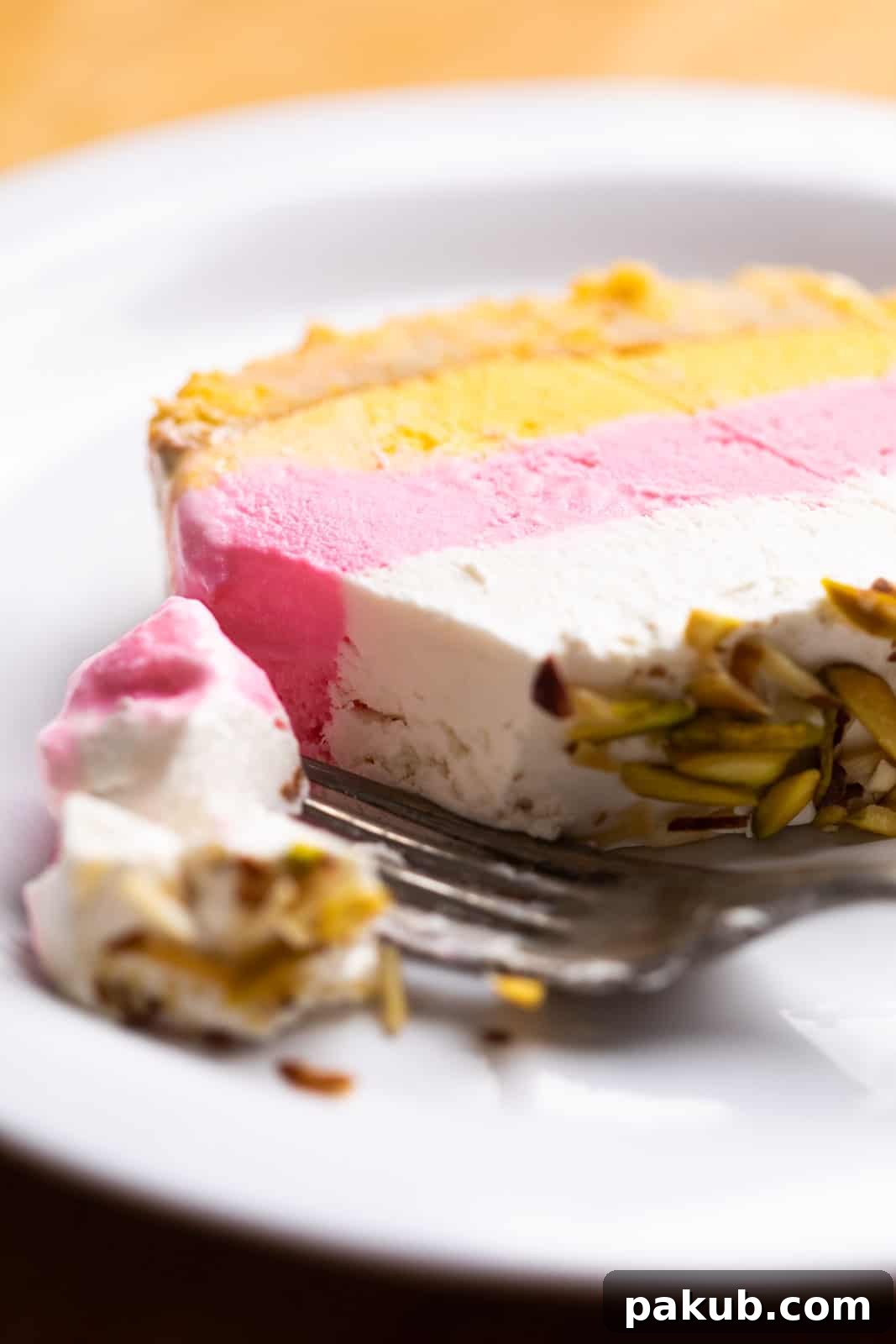 Modern Cassata Cheesecake 4 A delicious close-up of a bite taken out of the Classic Cassata with cheesecake, showing its creamy texture, layered goodness, and crunchy nuts.