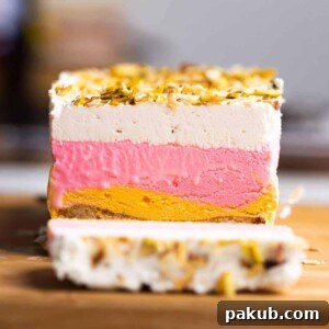 A vibrant slice of Classic Cassata showcasing its distinct cake, ice cream, and cheesecake layers.
