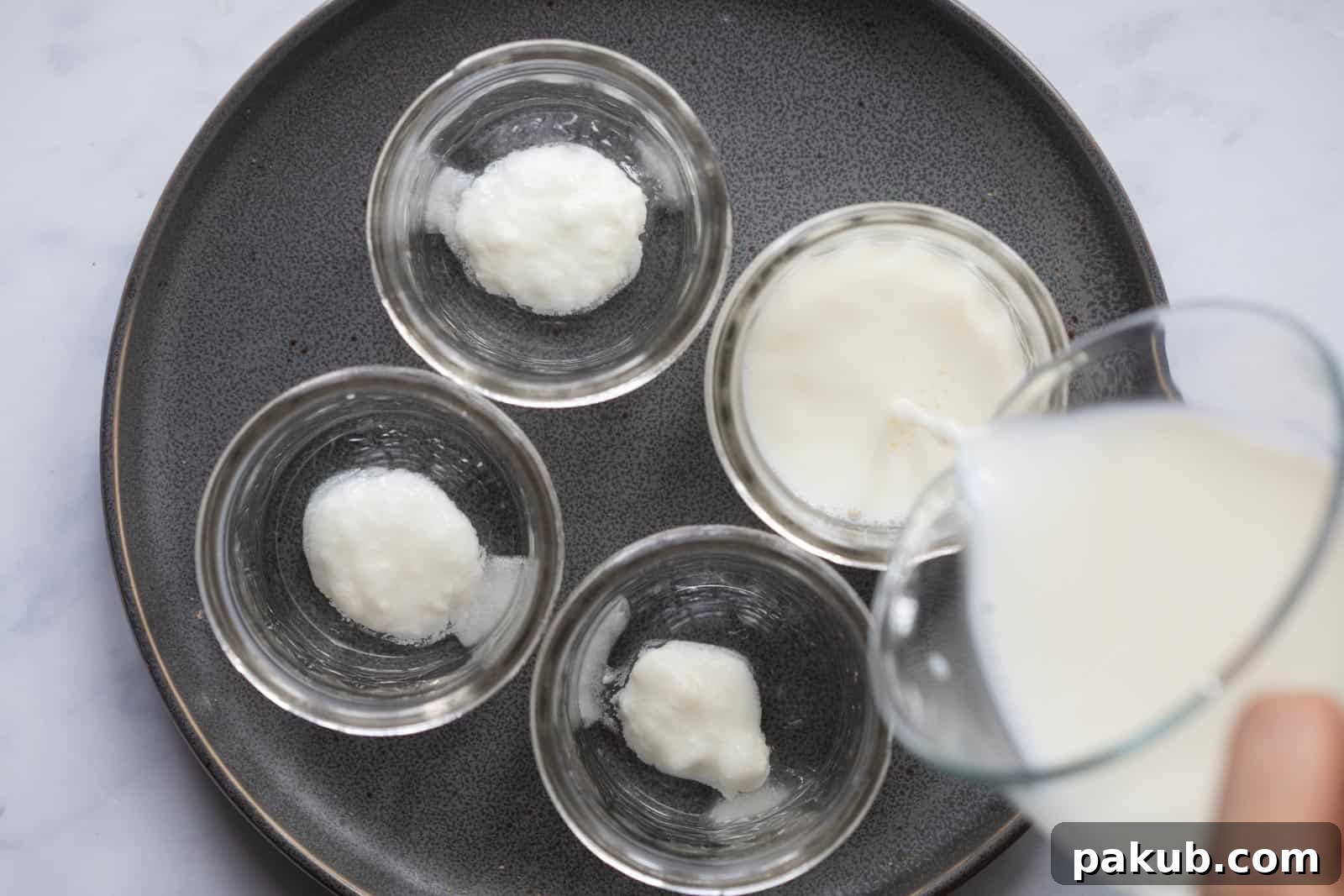 Milk being poured into mason jars to set yogurt