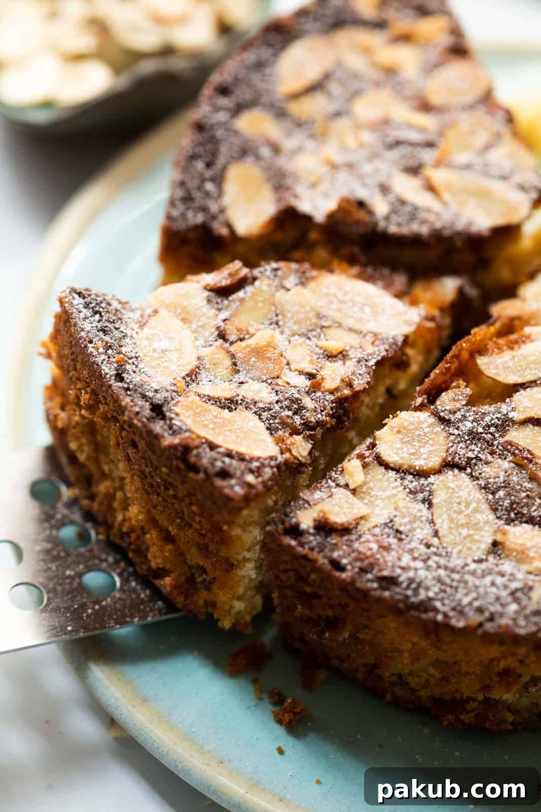 Scottish Dundee Cake: A Festive Delight 3 A large slice of Dundee cake being carefully lifted from the whole cake with a cake lifter, revealing its texture.