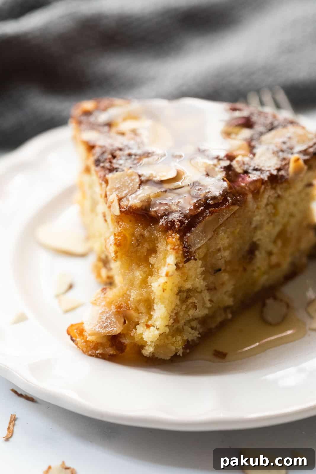 Scottish Dundee Cake: A Festive Delight 4 A close-up view of a perfectly baked slice of Dundee cake on a white plate, showcasing its moist, crumbly texture and evenly distributed fruits and nuts.