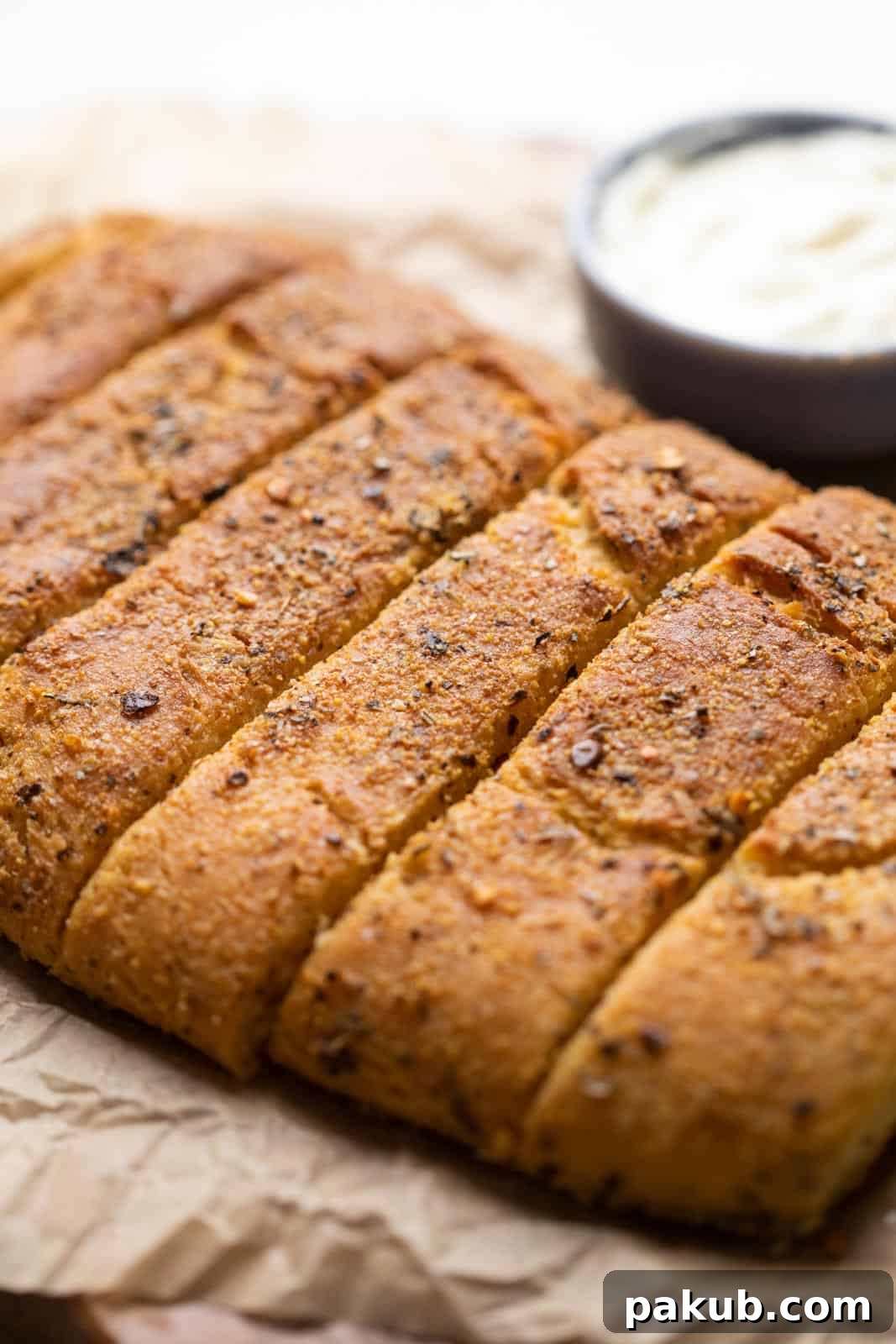 Ultimate Garlic Breadsticks Two Irresistible Styles 3 Crispy Domino's style garlic breadsticks placed on parchment paper, showing their perfectly baked, crunchy crust and golden hue.