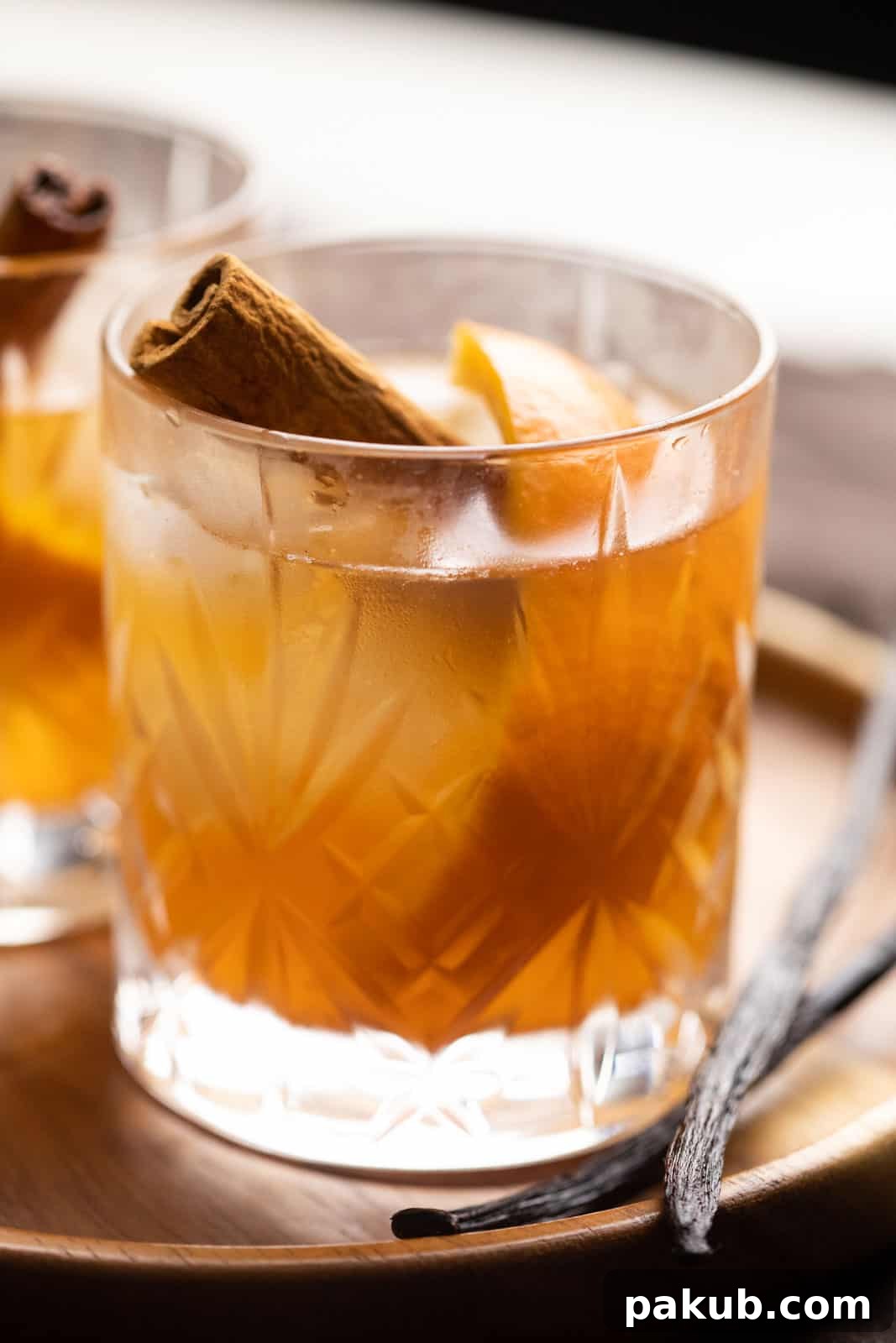 Golden Spiced Old Fashioned 3 Closeup of the vanilla cinnamon old fashioned showcasing the ice cube, orange peel, and cinnamon stick.