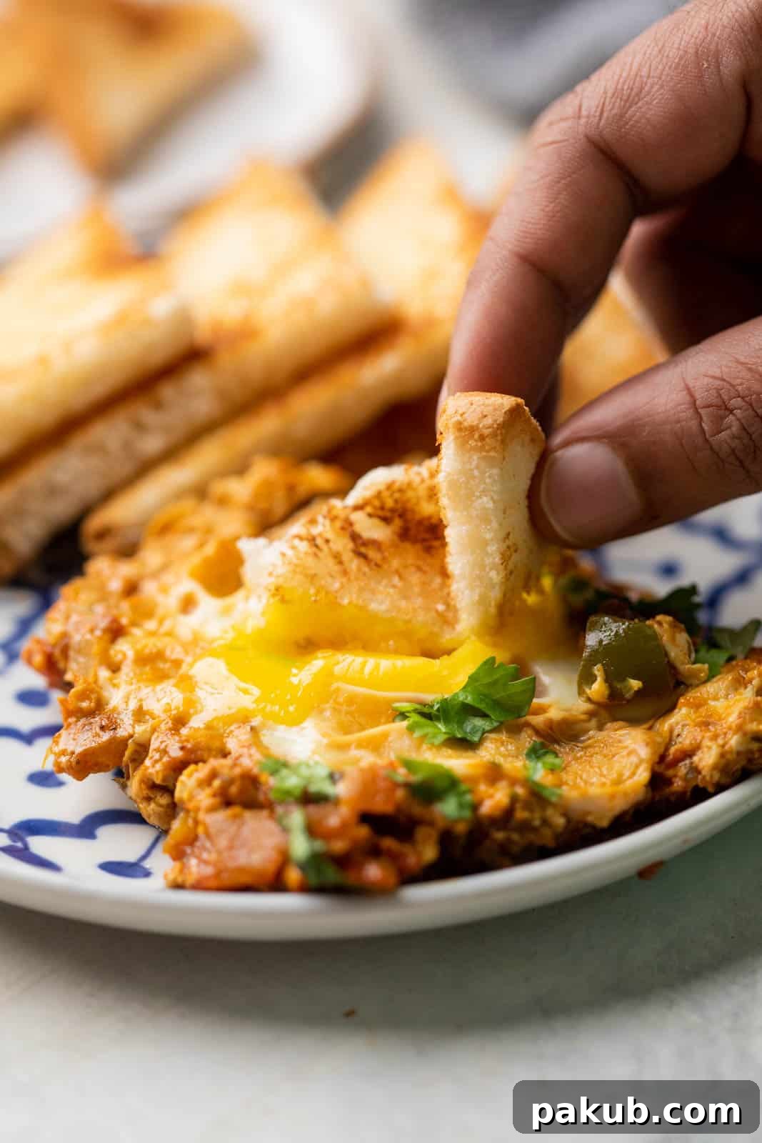 A slice of bread being dipped into the egg yolk