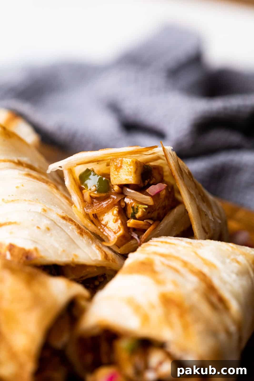 Chinese Paneer Kathi Rolls 2 Paneer kathi roll cut into pieces and stacked on top of the other