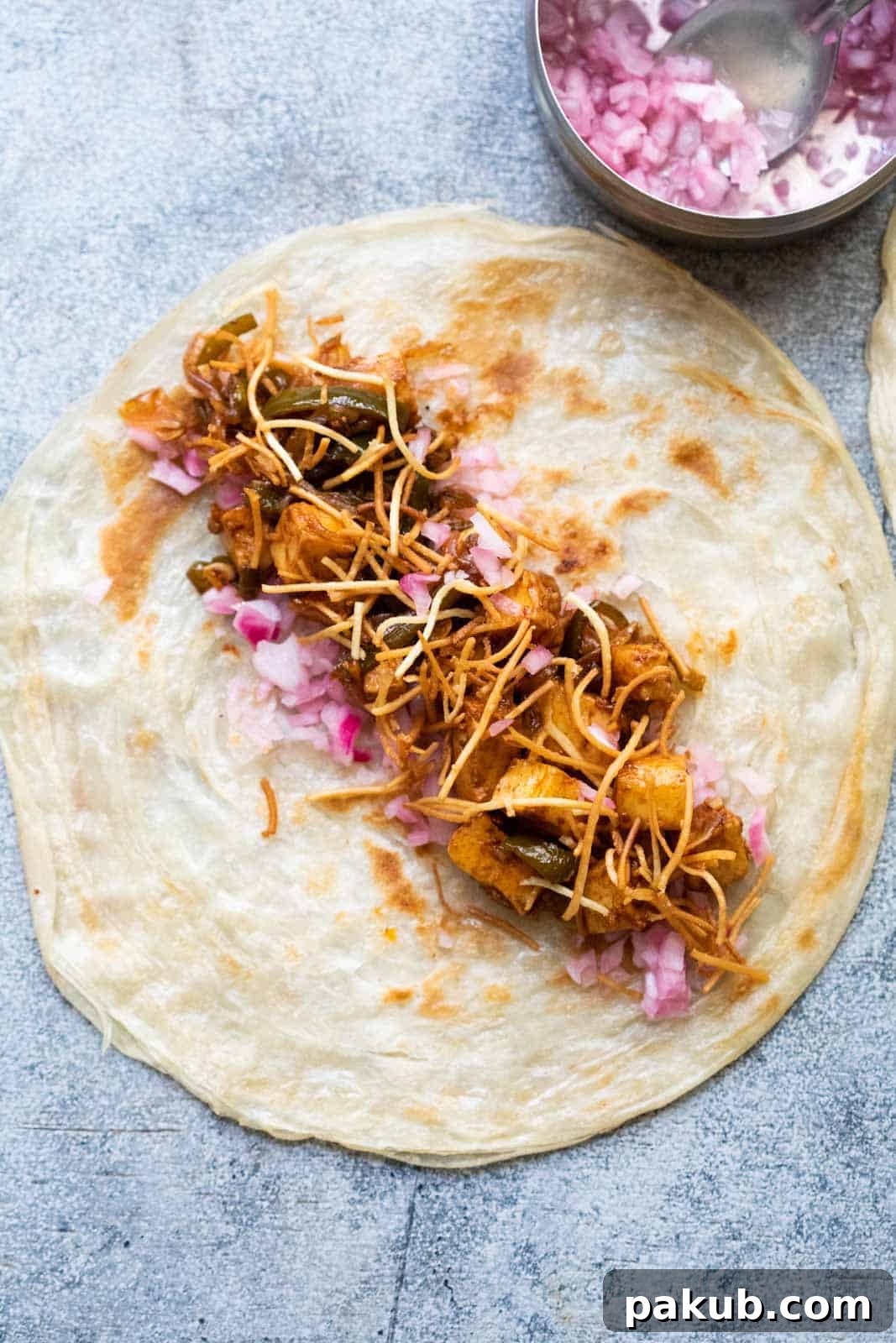 Chinese Paneer Kathi Rolls 3 A paratha laid out on the worktop with paneer filling and crispy noodles in it