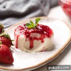 A serving of classic vanilla panna cotta with raspberry compote, ready to eat