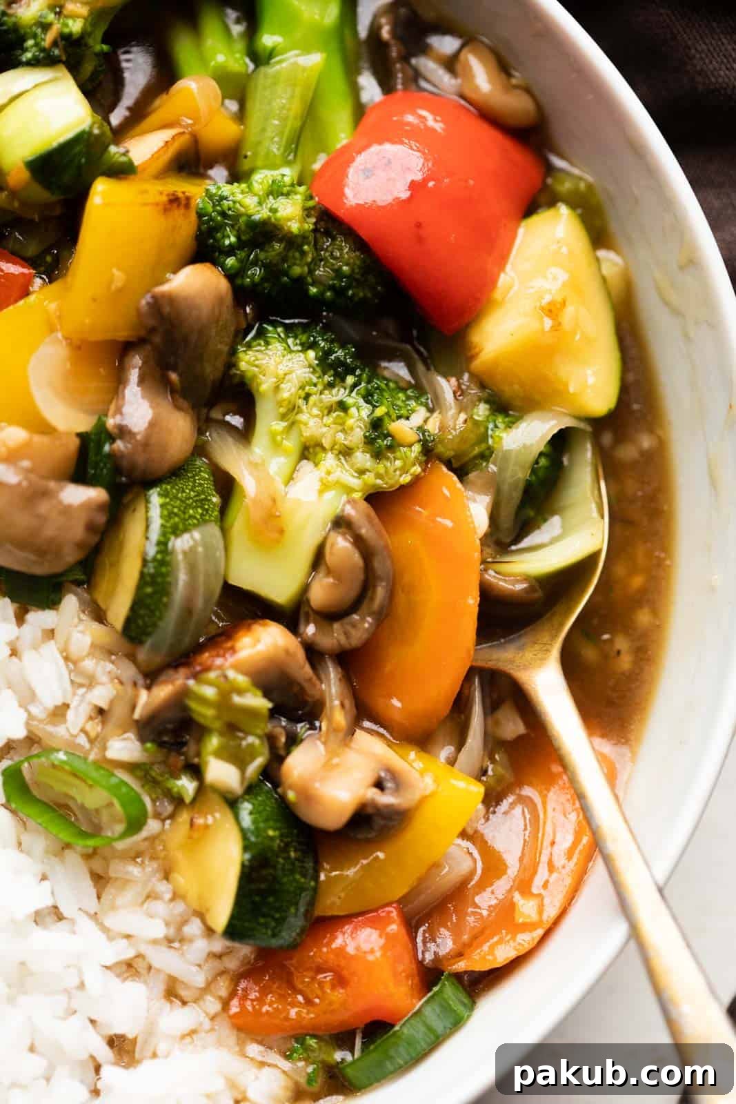 Effortless Asian Veggie Perfection 2 Closeup of Asian Veg Stir Fry served in a bowl over white rice, showcasing colorful vegetables and a rich sauce