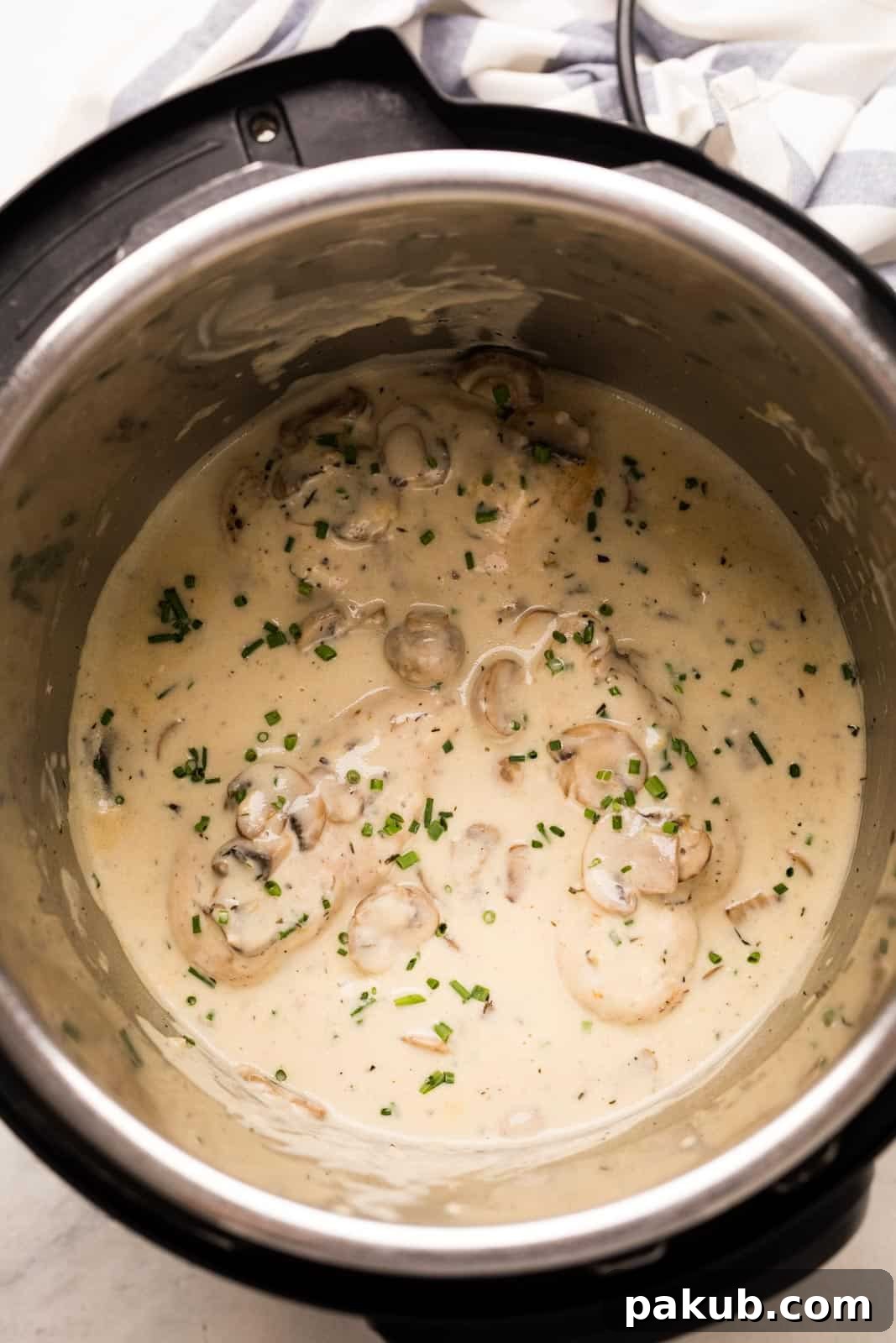 Instant Pot Creamy Mushroom Chicken 3 Cooked chicken breasts swimming in rich mushroom sauce inside the Instant Pot