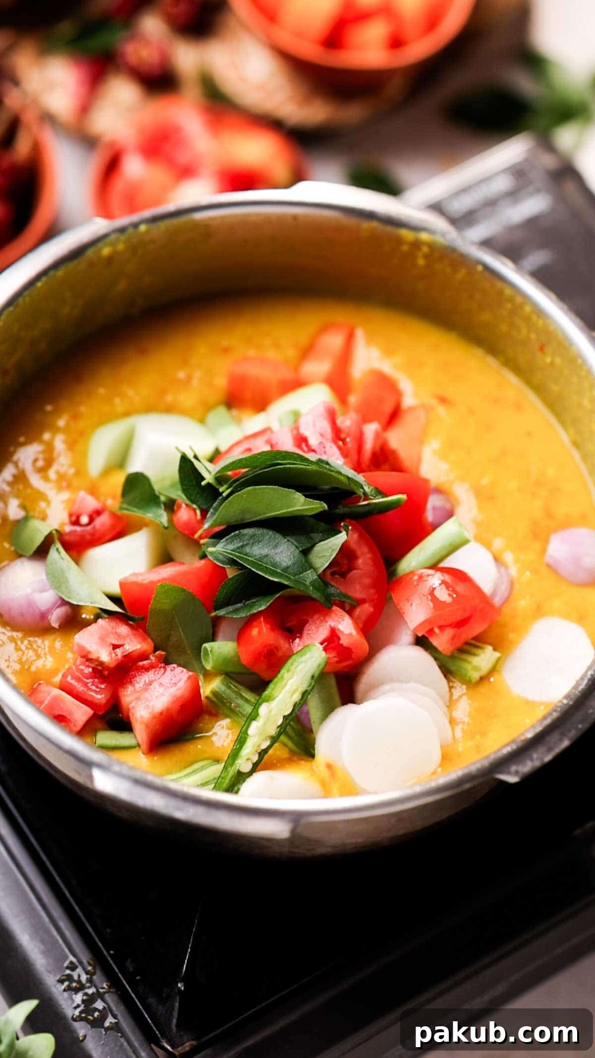 Assorted vegetables arranged over cooked dal, ready to be cooked further to make one-pot sambar.