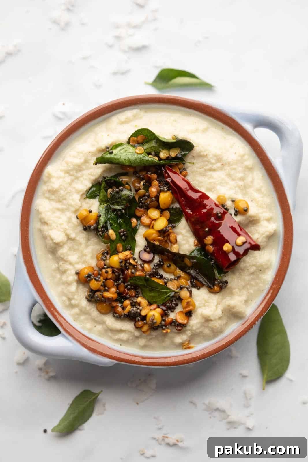 Unlocking Flavor: Chutneys for Idlis and Dosas 3 Coconut Chutney served in a light blue bowl with tempering on top