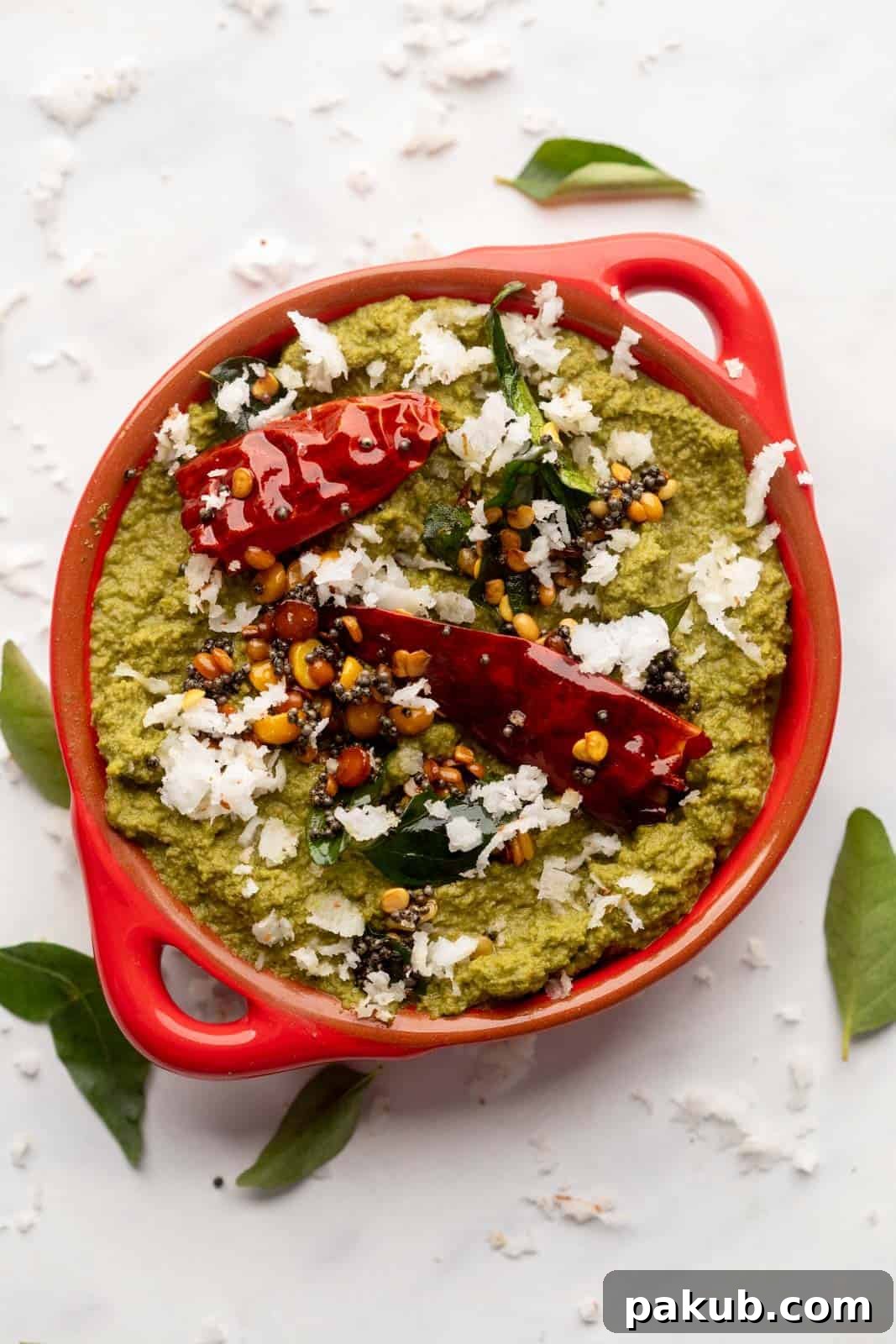 Unlocking Flavor: Chutneys for Idlis and Dosas 5 Coconut Coriander Chutney served in a red bowl with tempering on top