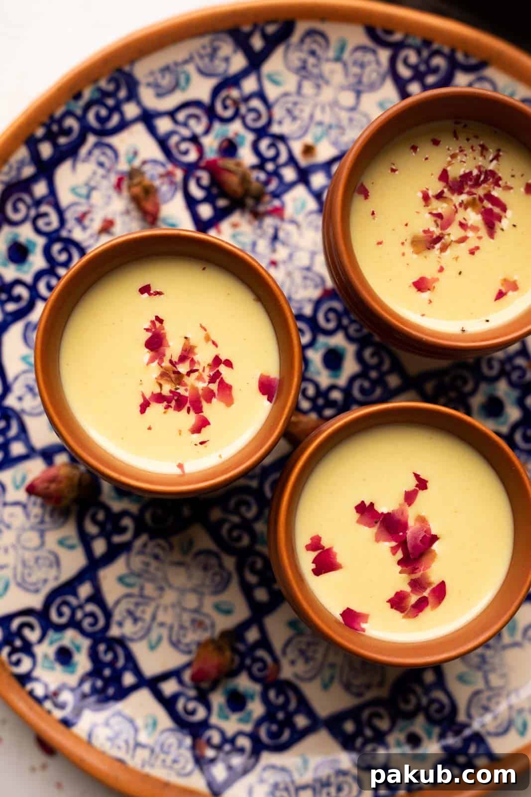 Holi Thandai Masterclass From Scratch 2 Thandai served in three mud glasses served on a colourful blue plate with rose petals on top