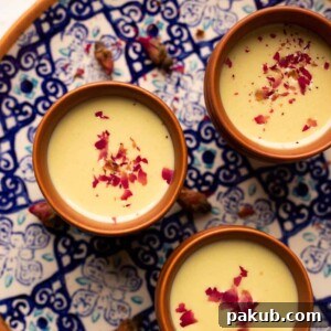 Thandai served in three mud glasses served on a colourful blue plate with rose petals on top