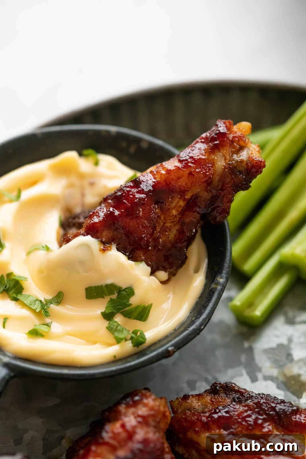 Kickin' BBQ Chicken Wings 5 A single chicken wing dipped into aioli
