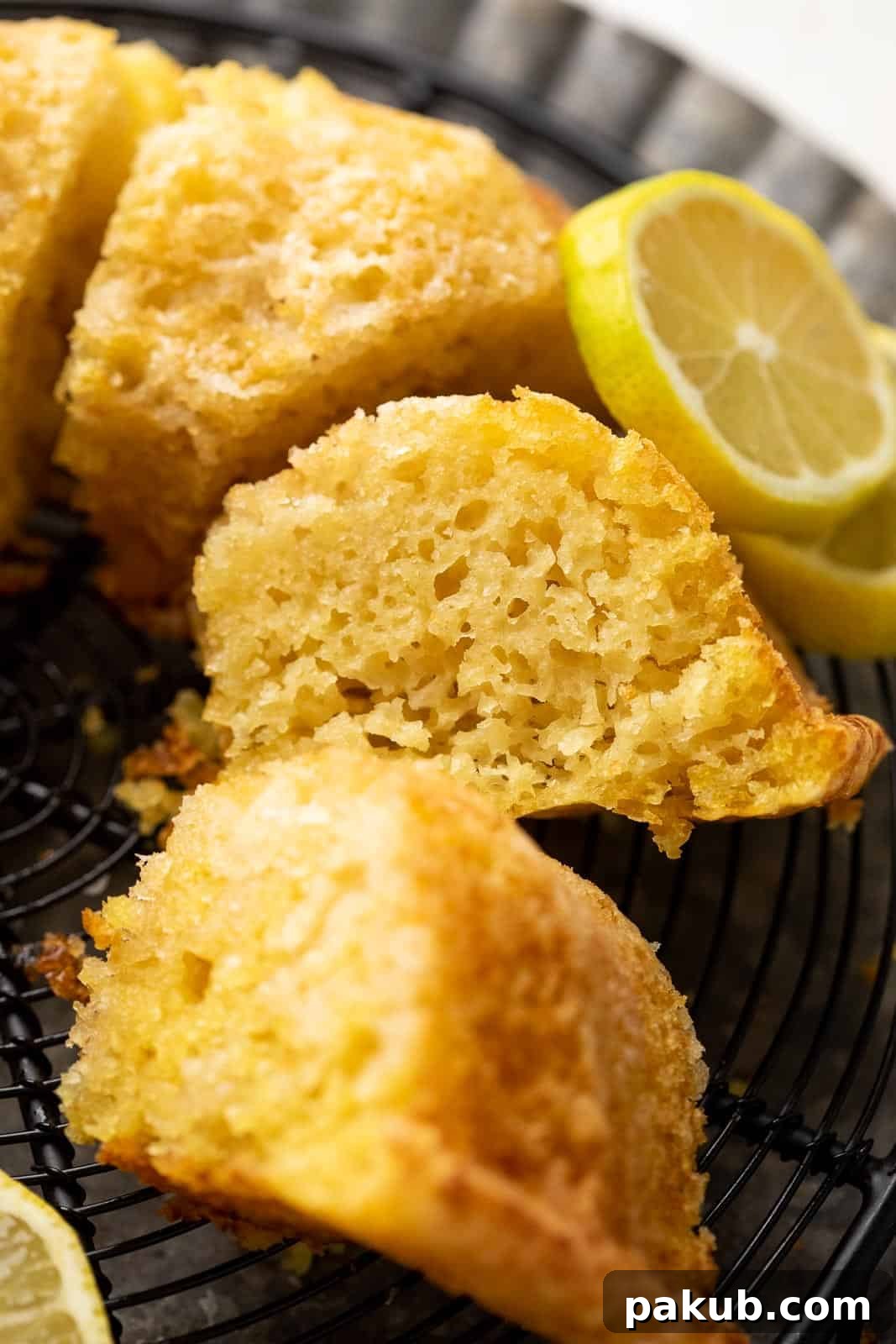 Light & Moist Eggless Lemon Cake 3 A perfectly cut slice of eggless lemon cake revealing its delicate, airy, and moist crumb texture, ready to be enjoyed with a cup of tea.