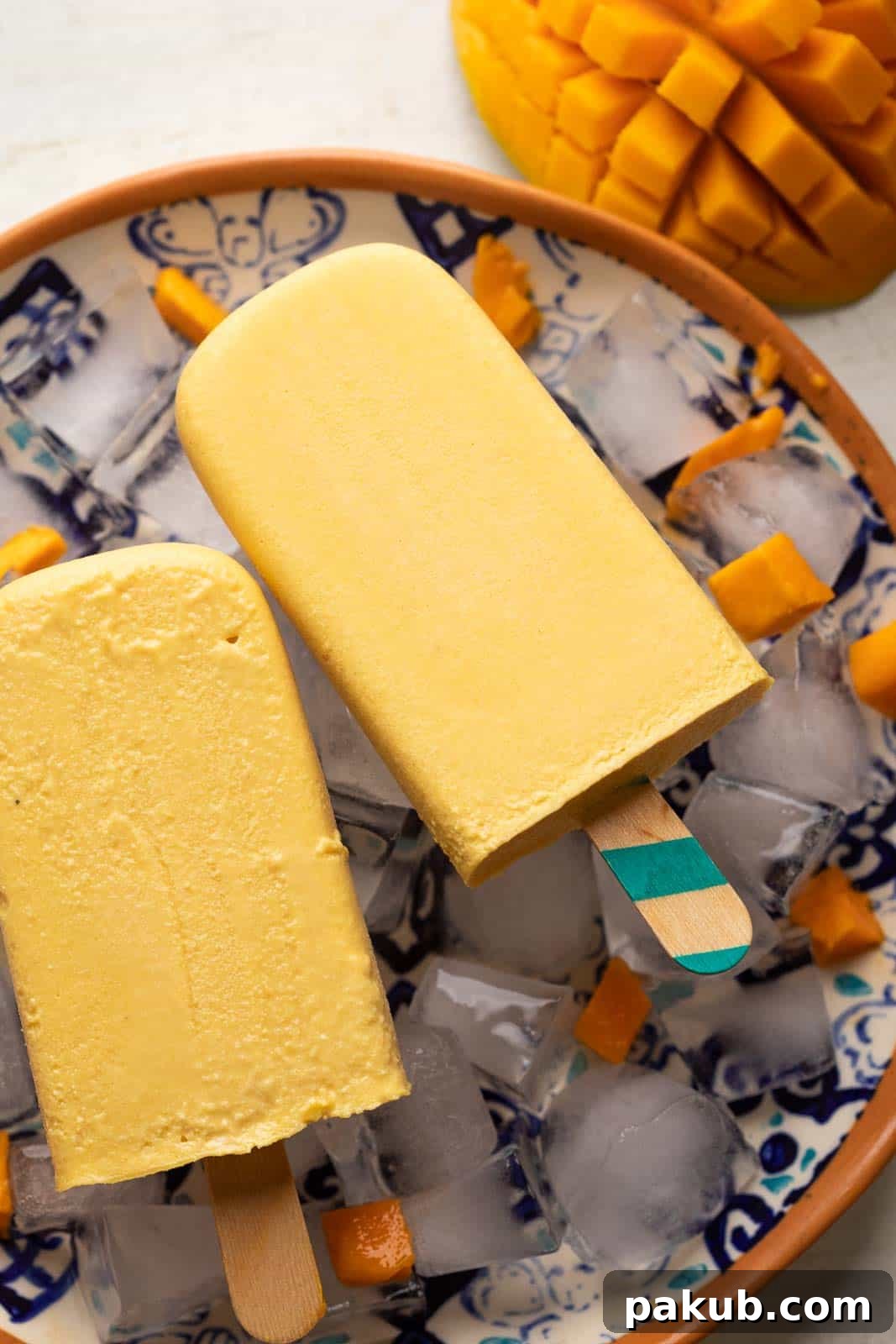 Kulfi Delights: Almond, Cream, and Mango Creations 5 Mango kulfi served on a plate with diced mangoes