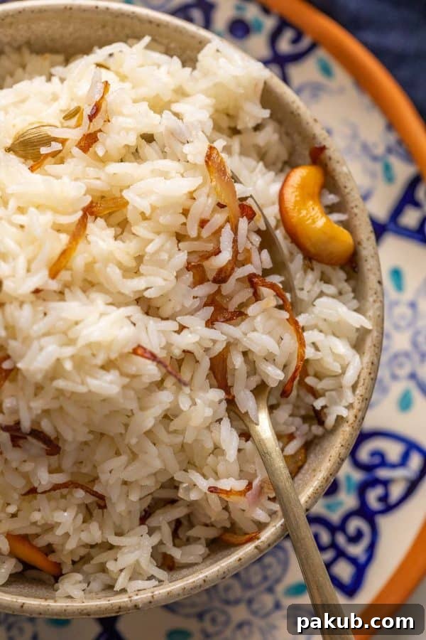 The Ultimate Ghee Rice 5 Closeup of ghee rice served in a brown bowl to show the texture of the rice
