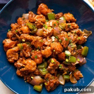 Easy Crispy Gobi Manchurian 7 Gobi Manchurian served in a blue bowl with garnishes.