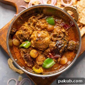 Kadai Chicken served in a copper kadai with tandoori roti and onions on the side