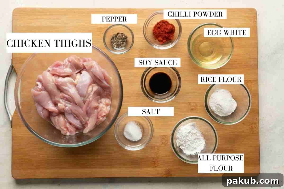 Ingredients for marinating and deep frying dragon chicken laid out with text to identify them