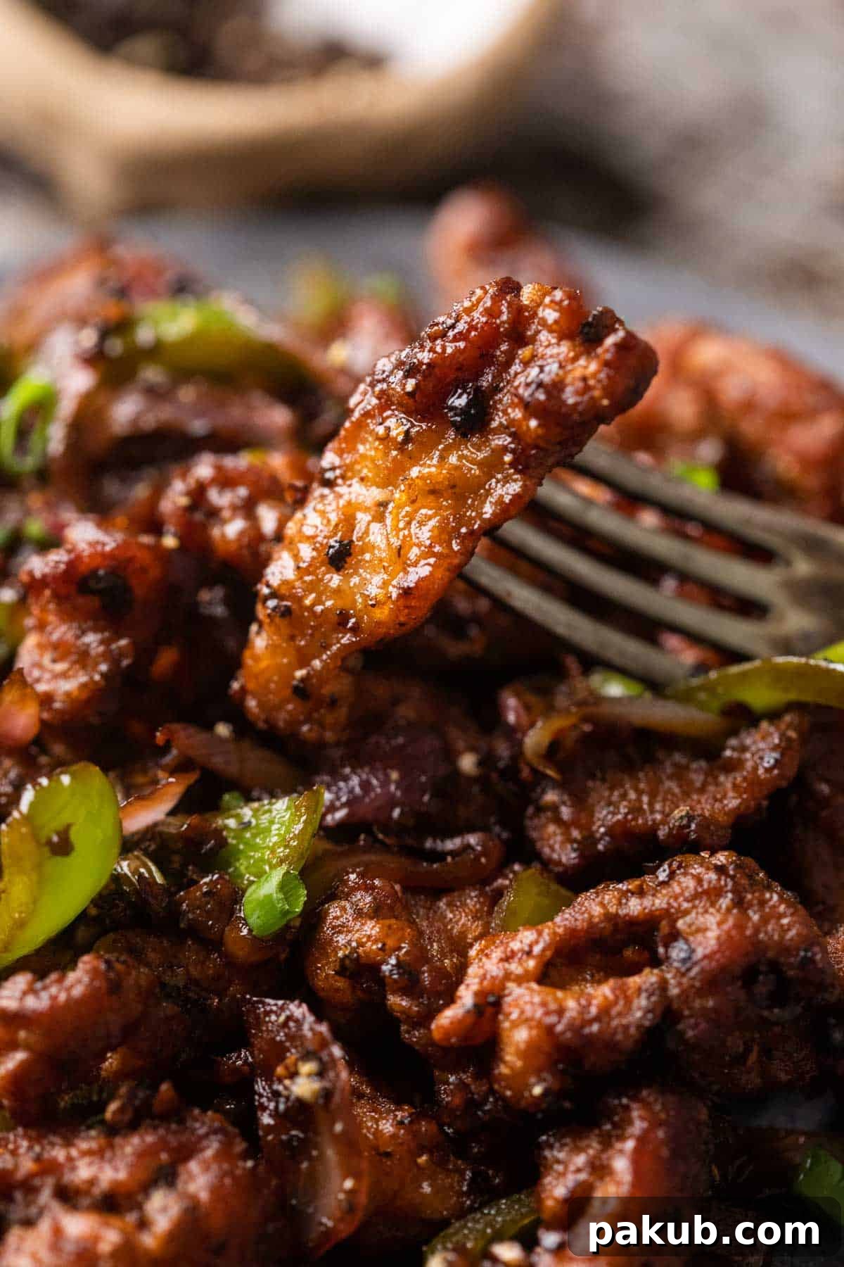 Salted Pepper Chicken Delight 6 Closeup of a piece of salt and pepper chicken on a fork