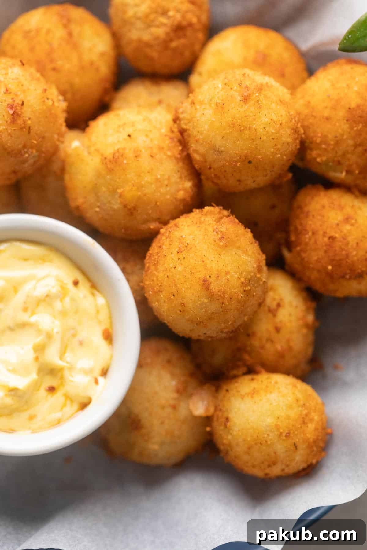 The No-Fail Secret to Amazing Cheese Balls 2 Cheese balls served in a bowl with a creamy achari dip
