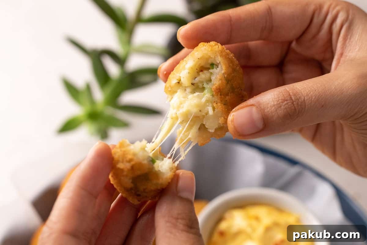 The No-Fail Secret to Amazing Cheese Balls 9 Picture of hands breaking a cheese ball apart to show the cheese pull