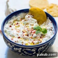 A close up of A picture of Garlicky yogurt party dip served in a blue bowl with chips