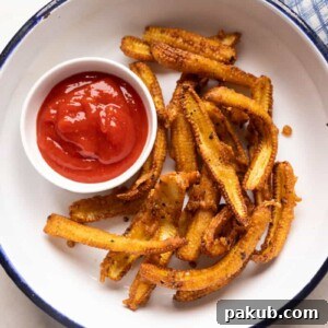 Crispy baby corn fry served in a white plate with ketchup on the side