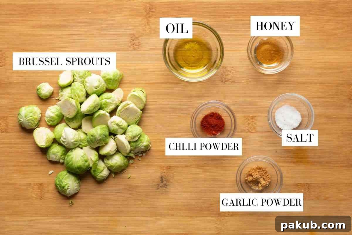 A beautifully composed flat lay image showcasing all the essential ingredients for air fryer brussels sprouts: fresh green brussels sprouts, a bottle of olive oil, a jar of golden honey, a small bowl of vibrant paprika, a heap of fragrant garlic powder, and a sprinkle of coarse salt, all perfectly arranged on a rustic wooden surface.
