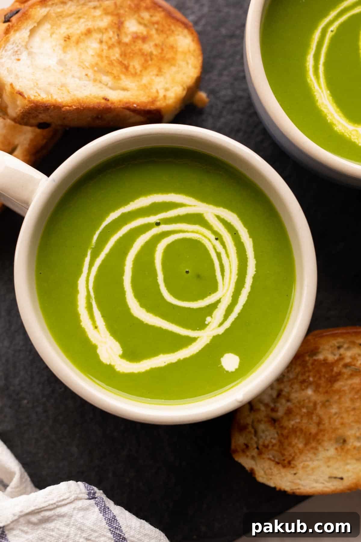 Velvety Spinach Delight 2 A beautifully presented bowl of creamy green spinach soup, garnished with a swirl of cream, served with toasted bread slices on the side