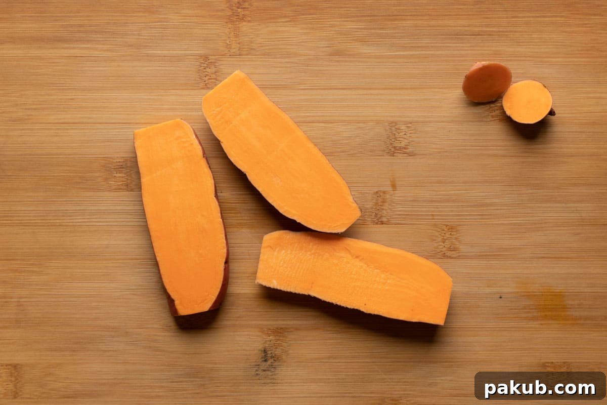 Carefully slicing a sweet potato into uniform 1/4 inch thick planks