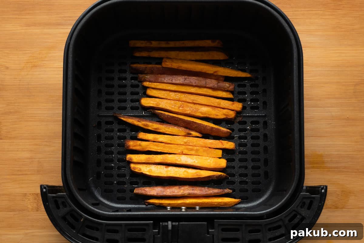 Perfectly roasted and golden brown sweet potato fries in the air fryer basket after cooking