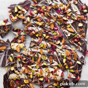 Exquisitely crafted chocolate bark, elegantly garnished with vibrant rose petals and crunchy pistachios.
