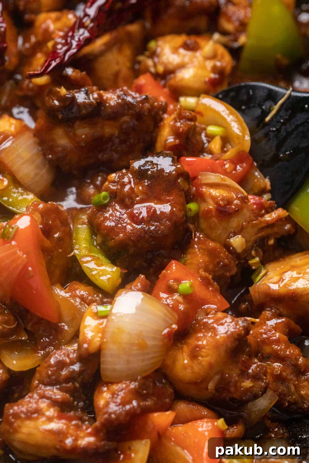 Spicy Szechuan Chicken Stir-Fry 2 Close up of Szechuan chicken in a wok, showcasing its vibrant color and glossy sauce.