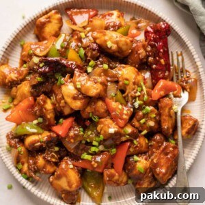 Szechuan Chicken served on a white plate with a fork