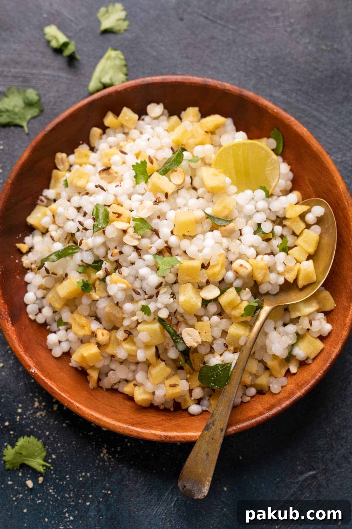 A perfectly prepared bowl of non-sticky Sabudana Khichdi, garnished with fresh coriander and a squeeze of lime.
