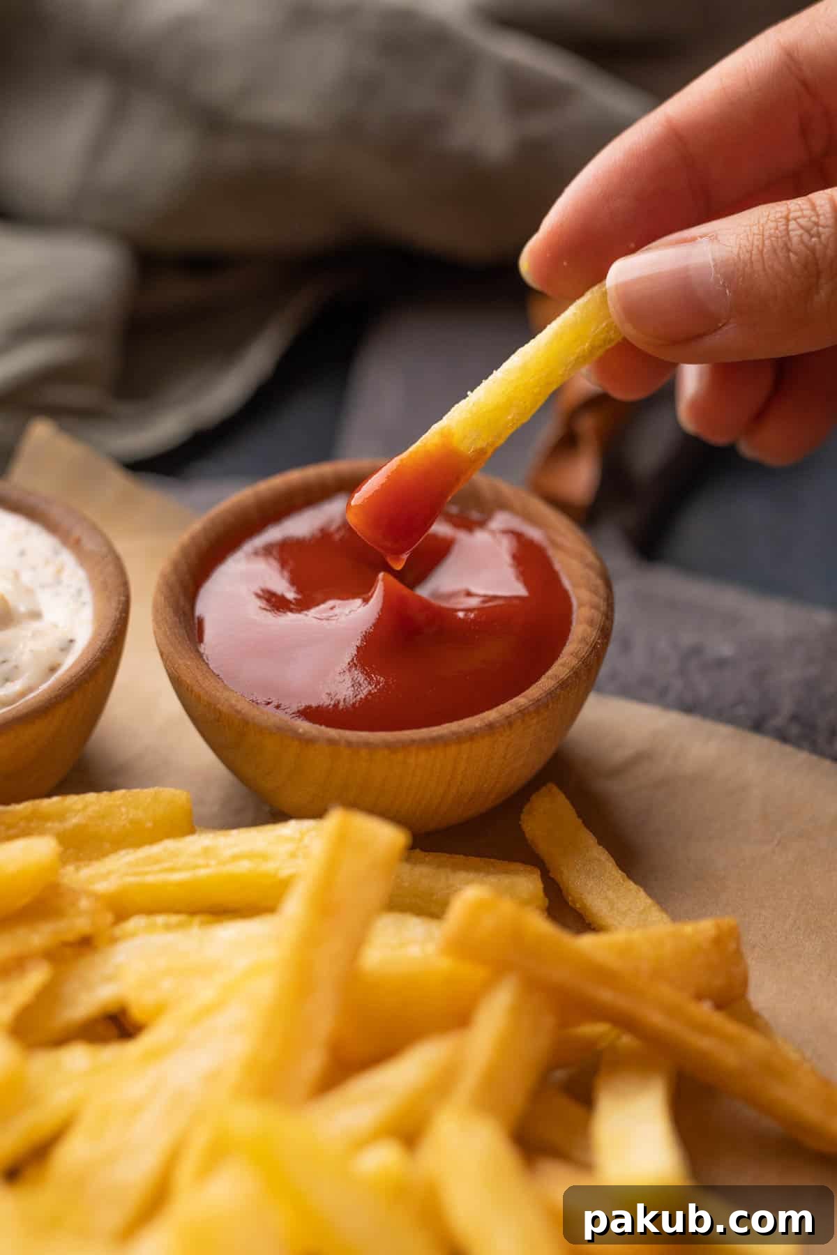 Crispy Golden French Fry Mastery 6 Close up of a crispy French fry dipped in bright red ketchup, showcasing its golden texture