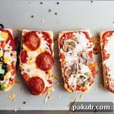 Golden-brown French bread pizza toasts fresh out of the oven on a baking sheet.