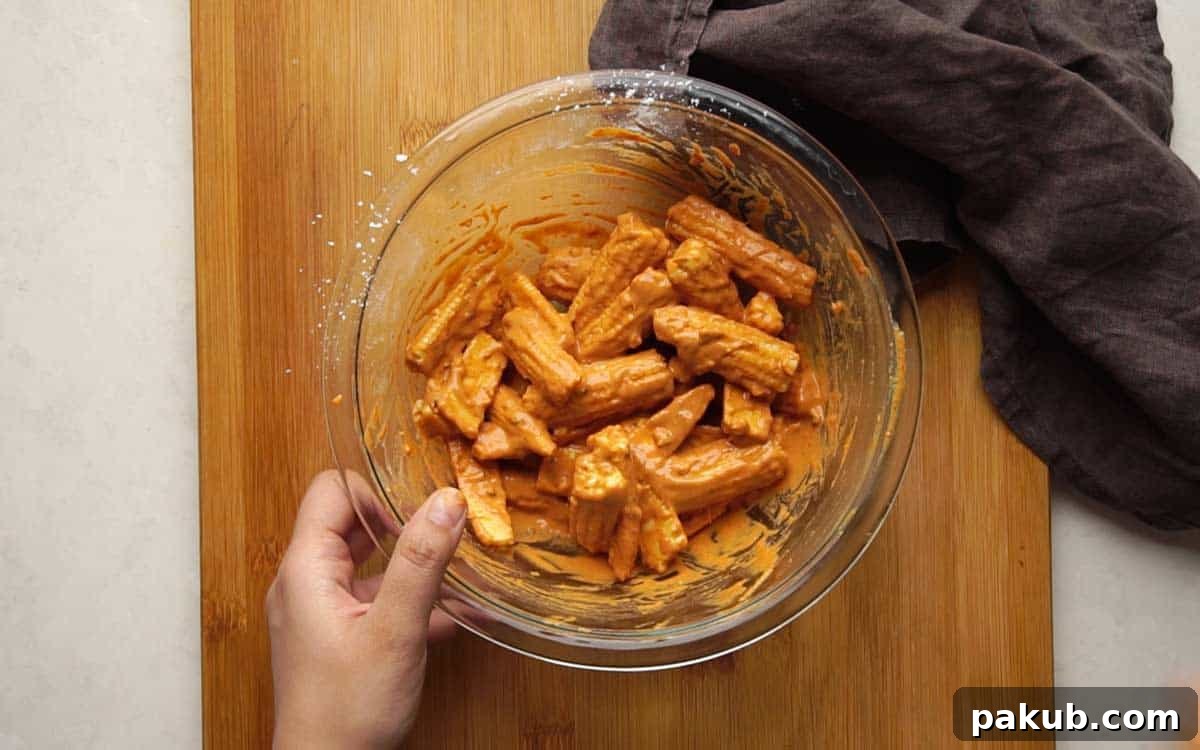 Irresistible Baby Corn Crisps 5 Picture showing how to evenly coat baby corn pieces in the prepared batter