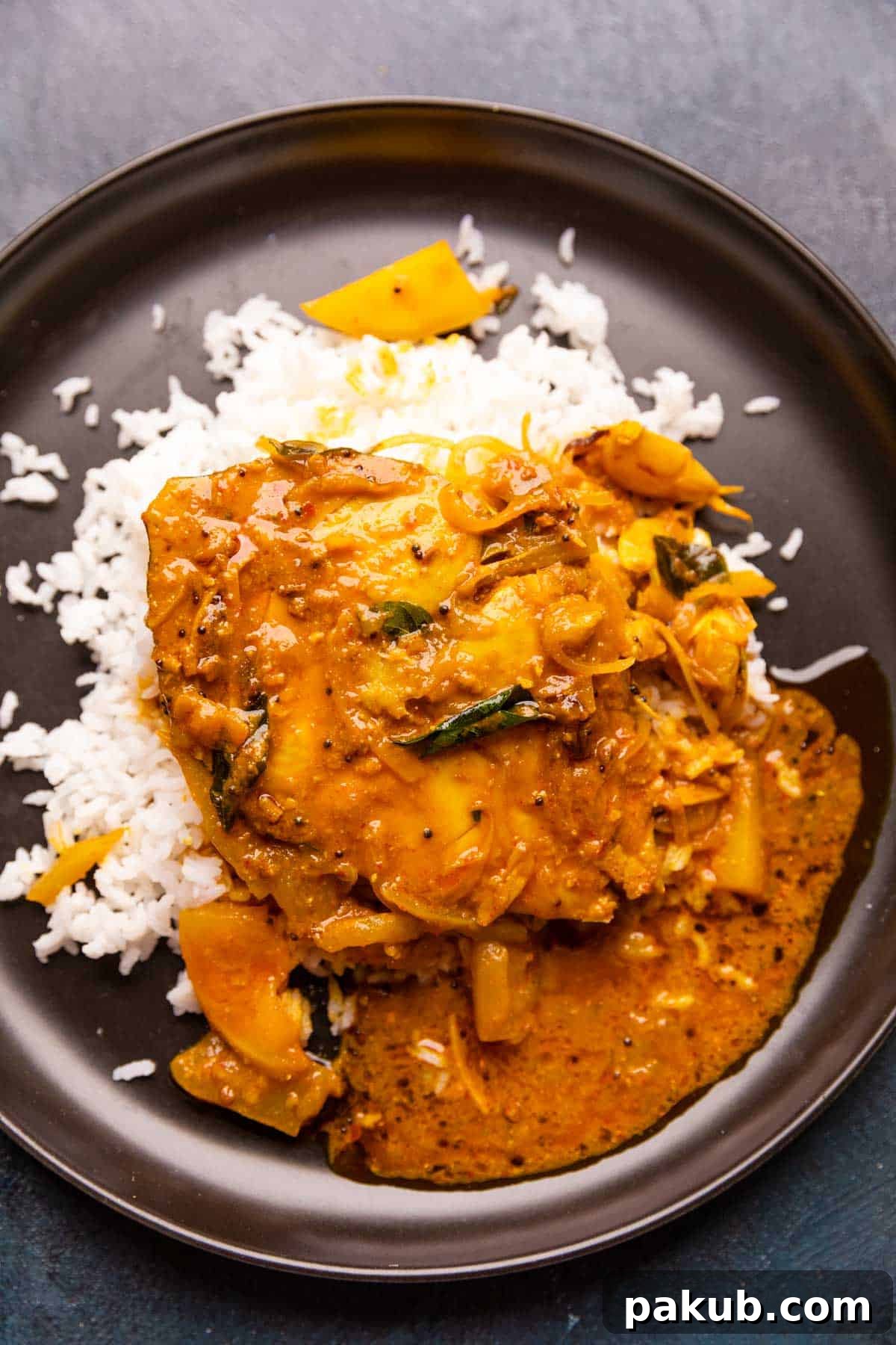 Alleppey Green Mango Fish Curry 7 A plate of rice with raw mango fish curry on top of the rice